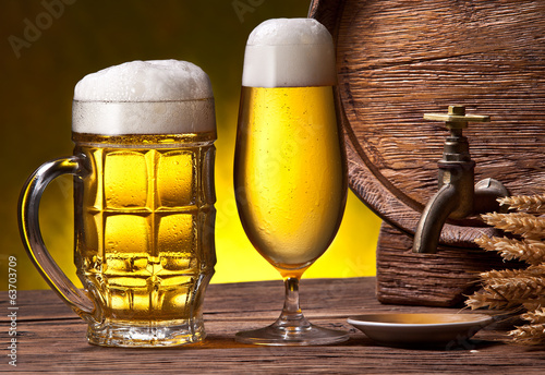 Beer glasses, old oak barrel and wheat ears. photo