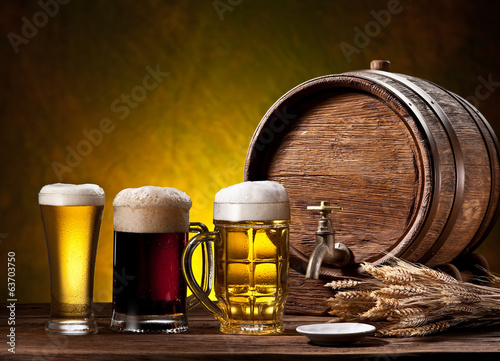 Beer glasses, old oak barrel and wheat ears.