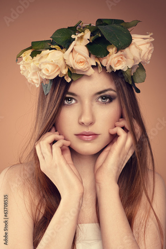 Spring girl. Young elegant woman with roses bouquet in hair © Stasique