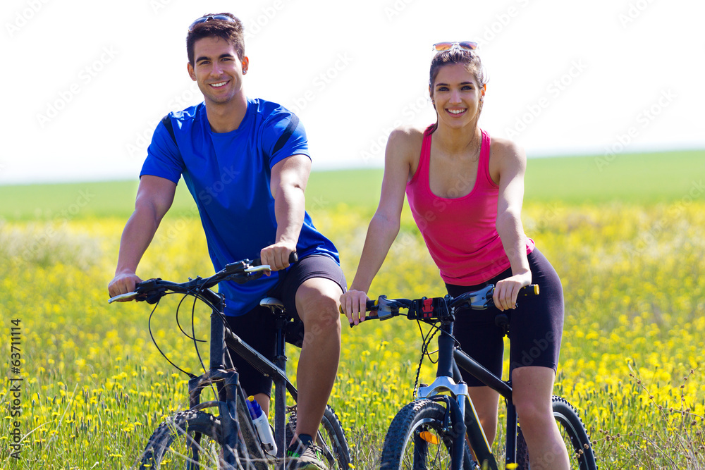 Happy young couple on a bike ride in the countryside Happy young couple on a bike ride in the countryside