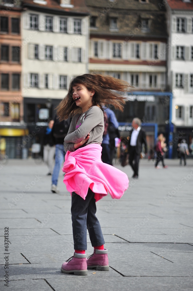 Girl spins around herself in the square