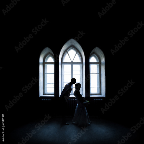 silhouette kissing couple near the vintage window