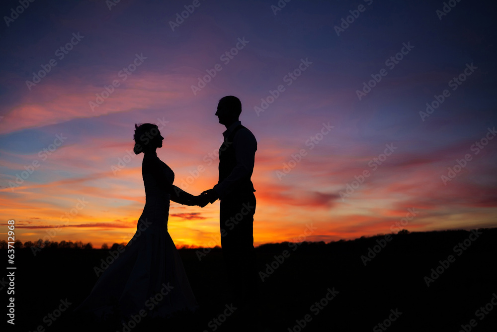 loving couple holding hands at sunset
