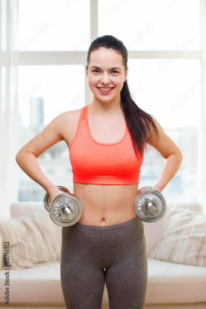 smiling girl exercising with dumbbells smiling girl exercising with dumbbells