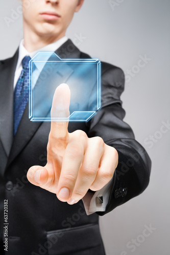 Businessman pressing high-tech virtual button with copy space