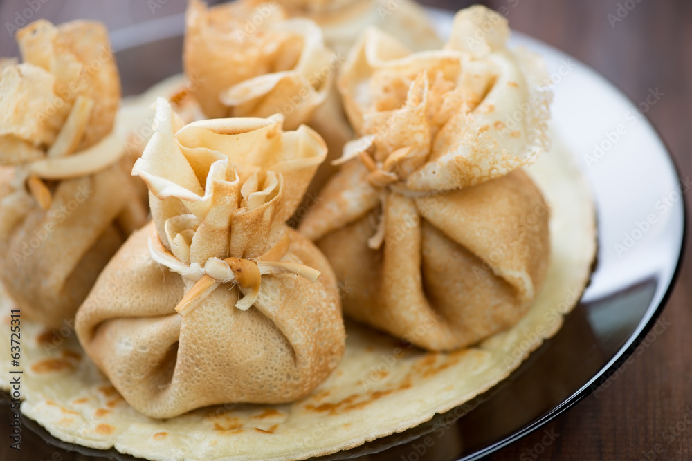Glass plate with stuffed pancakes, horizontal shot, close-up Glass plate with stuffed pancakes, horizontal shot, close-up