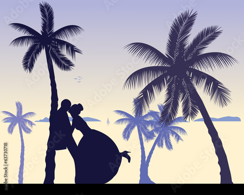 Wedding couple between the palms on the beach