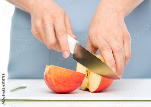 Cook is chopping apple