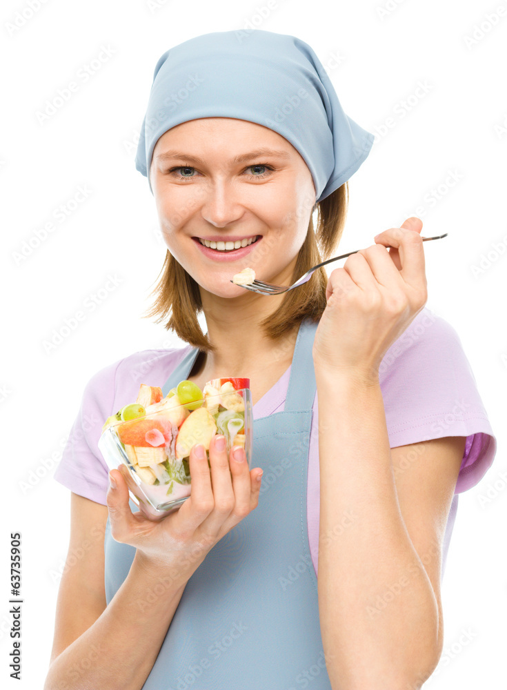 Young attractive woman is eating salad using fork Young attractive woman is eating salad using fork
