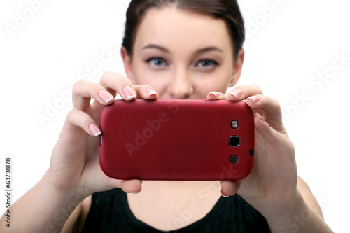 молодая девушка в черном платье фотографирует на телефон
