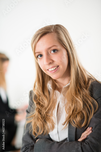 Cheerful young business woman standing up in the office