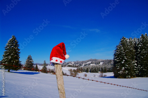 rote weihnachtsmütze auf zaun © bildkistl