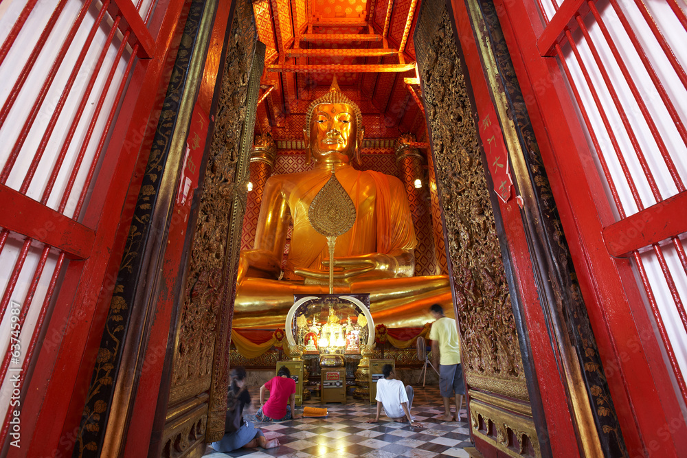 human and huge gold buddha in thailand