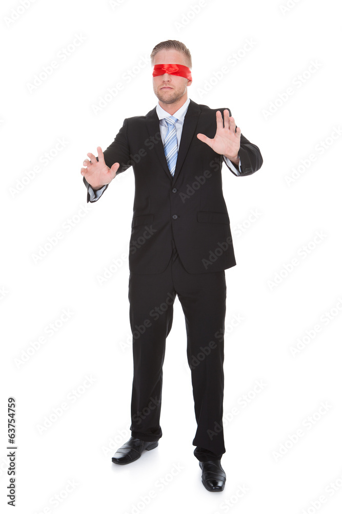 Stylish young businessman wearing a red blindfold Stylish young businessman wearing a red blindfold