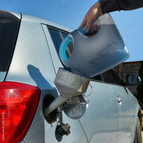 pouring fuel into the car gas tank photo