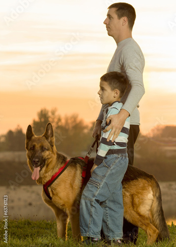 Dad and son and German shepherd in nature watching the sunset © V&P Photo Studio