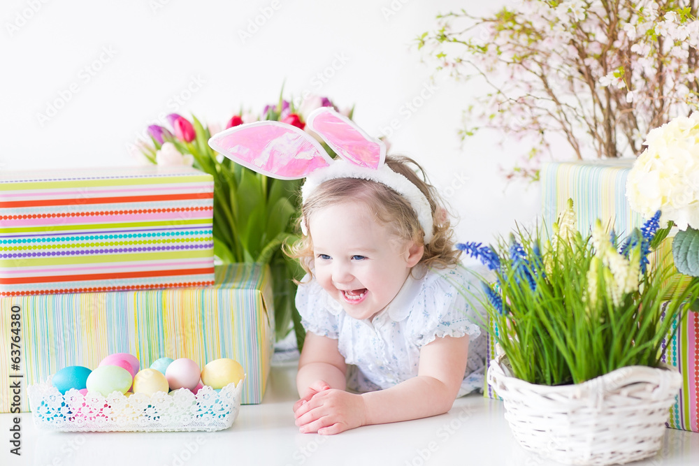 Little toddler girl with rabbit's ears next basket of eggs Little toddler girl with rabbit's ears next basket of eggs