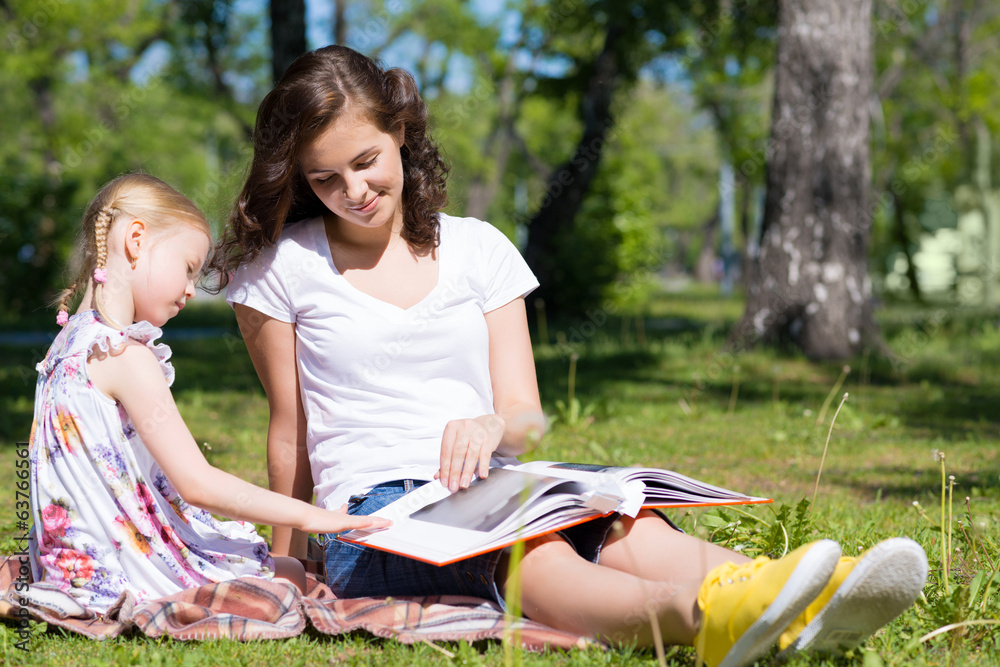 girl and a young woman reading a book together