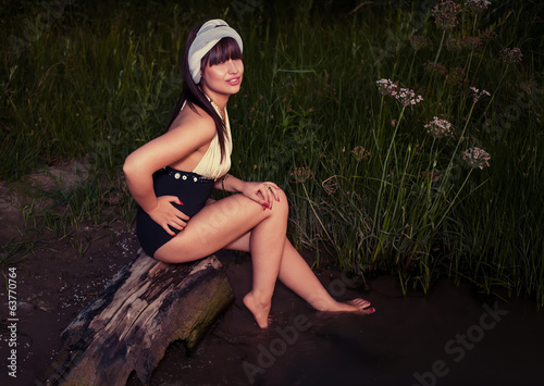 Retro looking  women sitting on driftwood