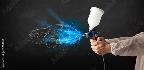 Фотография Worker with airbrush gun painting hand drawn car lines