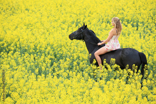 young woman riding on a black horse