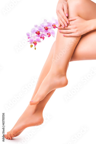 female legs and hand with orchid flower. isolated