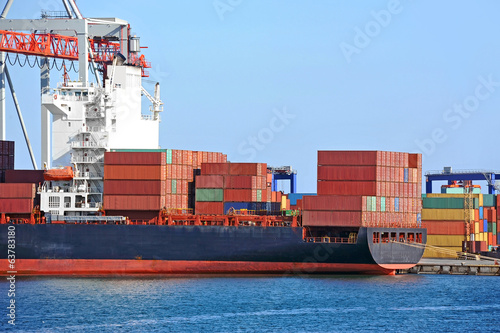 Container stack and ship under crane bridge