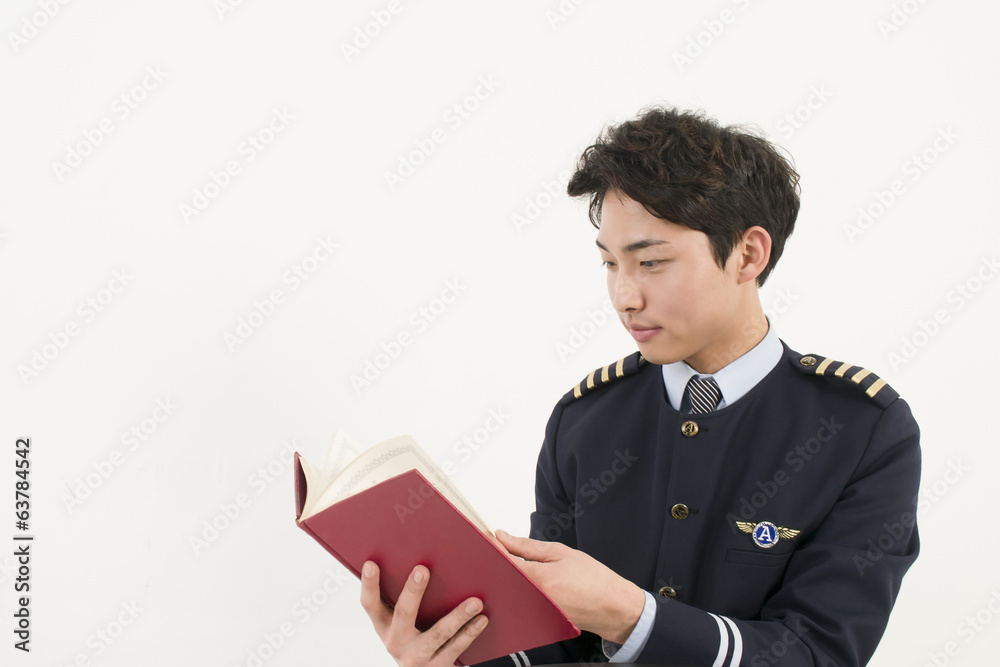Airline pilot reading a book Stock Photo | Adobe Stock