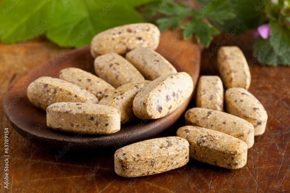 Herbal vitamin and supplement pills on spoon Herbal vitamin and supplement pills on spoon