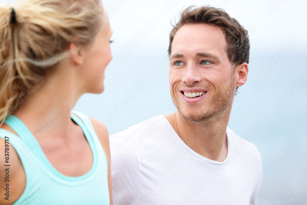 Couple jogging training together running on beach Couple jogging training together running on beach