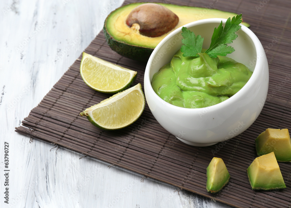 Fresh guacamole in bowl on wooden table Fresh guacamole in bowl on wooden table