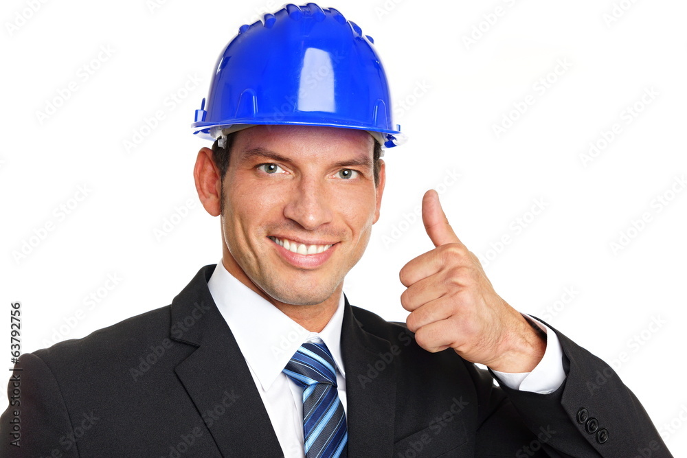 Handsome businessman in a protective helmet shows you thumbs up Handsome businessman in a protective helmet shows you thumbs up