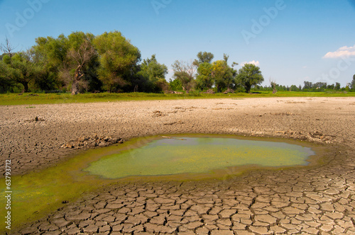 Photo Polluted water and cracked soil during drought