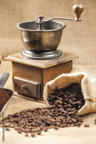 still life of coffee beans in jute bag with coffee grinder