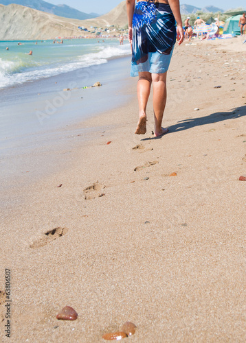 woman walking on the sand beach © vladis_studio