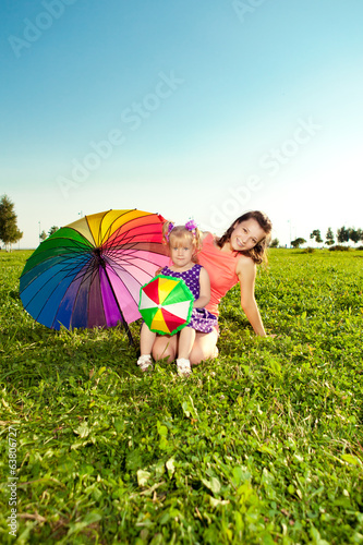 Cute little girl with mother colored balloons and rainbow umbrel photo