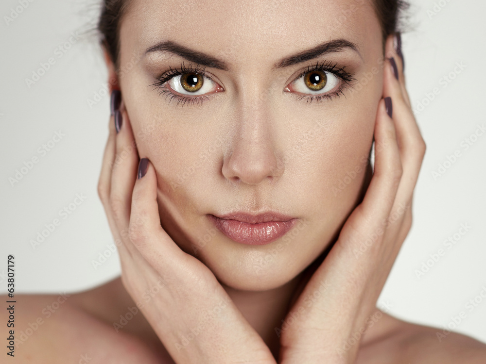 Beauty portrait of young pretty woman touching her face Beauty portrait of young pretty woman touching her face