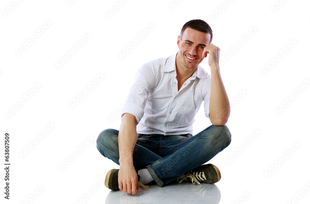 Handsome happy man sitting at the floor over white background Handsome happy man sitting at the floor over white background