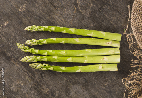 Green asparagus on old wooden background