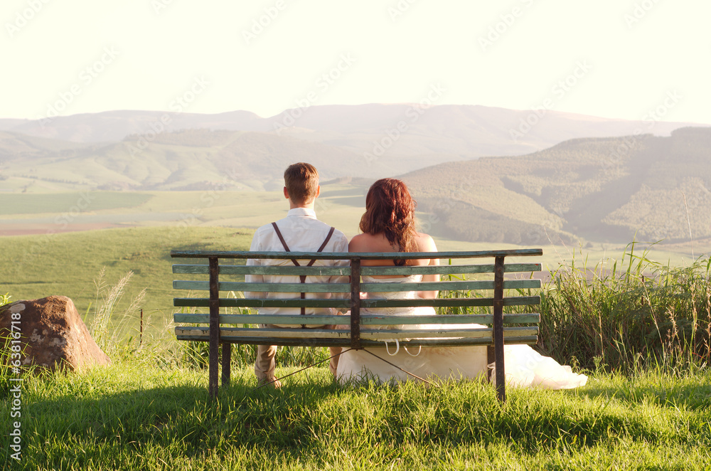 African bride and groom on bench with landscape African bride and groom on bench with landscape