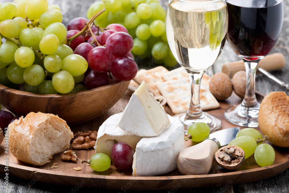 Camembert, fresh baguette, grapes and wine on a wooden tray Camembert, fresh baguette, grapes and wine on a wooden tray