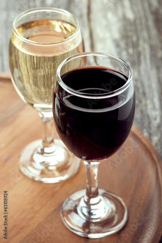 glass of red and white wine on a wooden board