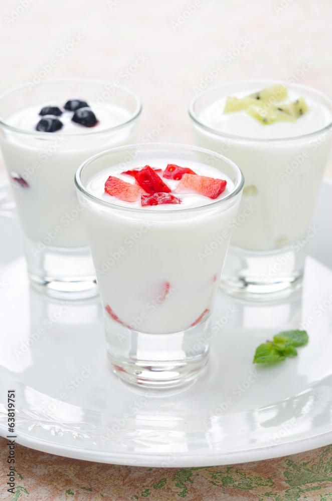 three yogurt with fruit in a glass beaker three yogurt with fruit in a glass beaker