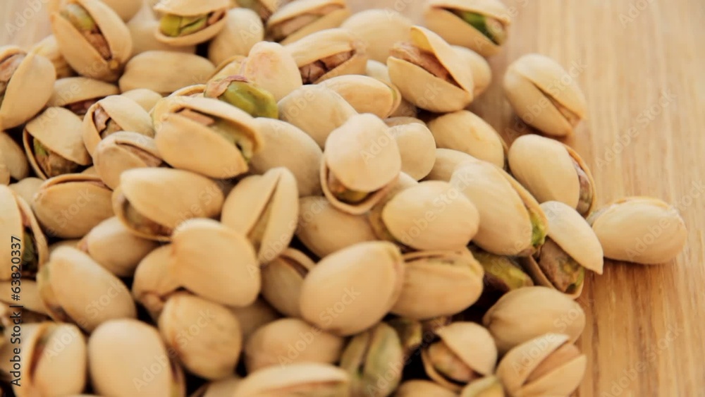 Roasted pistachios rotate on wood plate, video Roasted pistachios rotate on wood plate, video