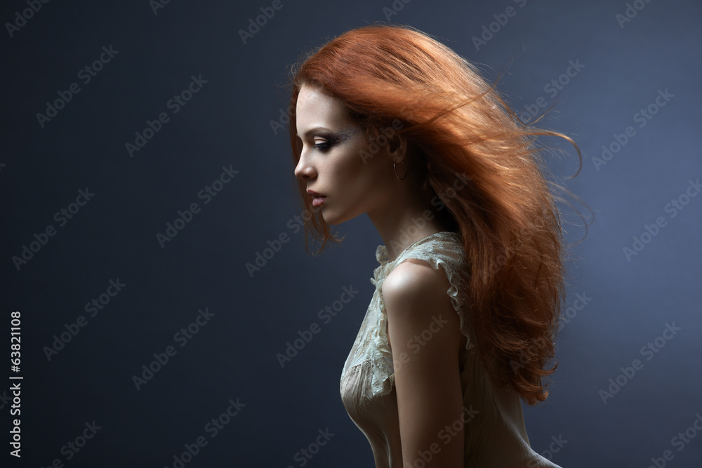 Naklejka premium beautiful red-haired girl in the dark