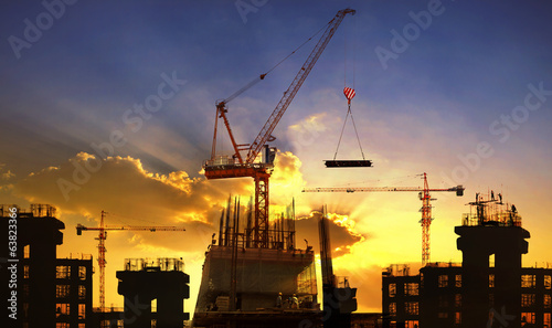 big crane and building construction against beautiful dusky sky photo