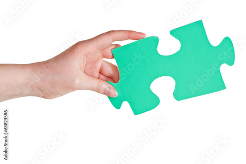 female hand holding big green paper puzzle piece