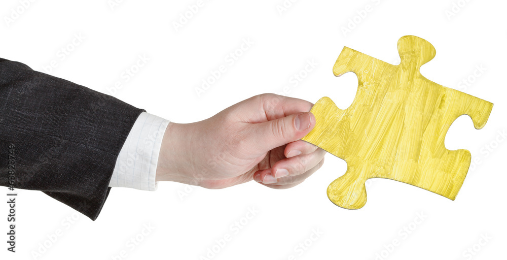 male hand with painted yellow puzzle piece male hand with painted yellow puzzle piece