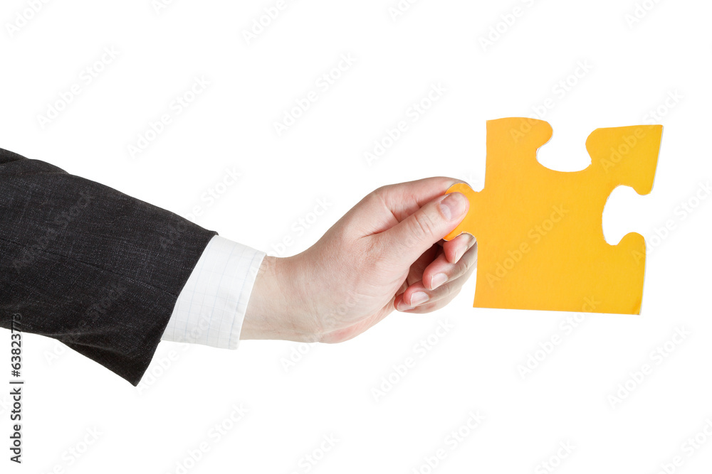 male hand holding big yellow paper puzzle piece male hand holding big yellow paper puzzle piece