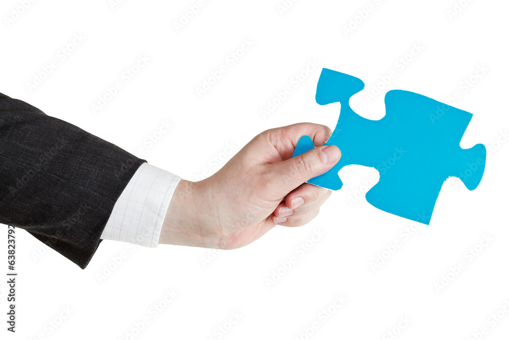 male hand holding big blue paper puzzle piece male hand holding big blue paper puzzle piece